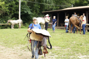 Scout Carrying A Saddle